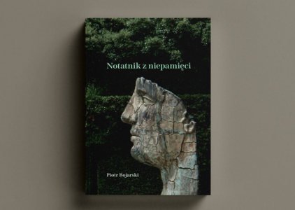 Okładka tomiku wierszy prof. Piotra Bojarskiego Notatnik z Niepamięci: ciemnozielone tło, a na nim rzeźba: twarz rozpadająca się na kawałki