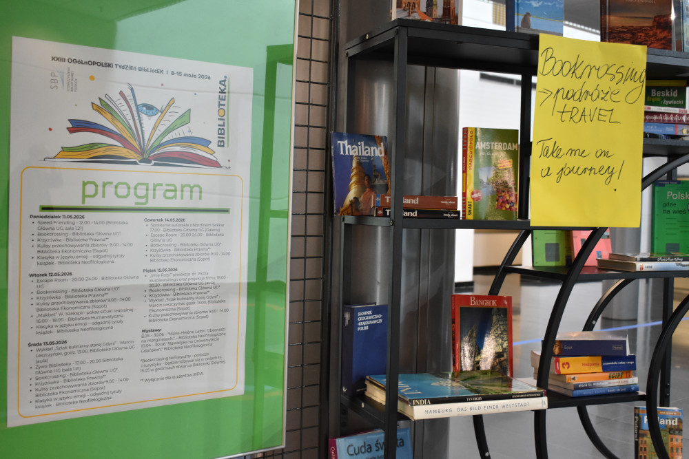 Tydzień Bibliotek na Uniwersytecie Gdańskim - relacja. Zdjęcie plakatu wydarzenia, obok regał z bookcrossingiem