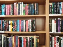 Nowy kącik beletrystyczny w Bibliotece Ekonomicznej. Na zdjęciu są regały z książkami, wokół wysokie fotele i lampa. 